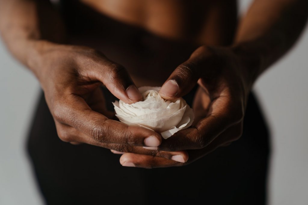 Homme torse nu tenant une fleur blanche en main
