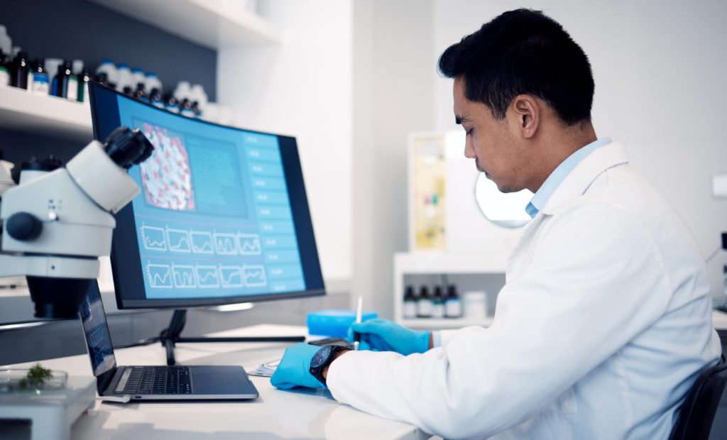 Laborantin faisant des analyse, regardant des données sur un logiciel de laboratoire